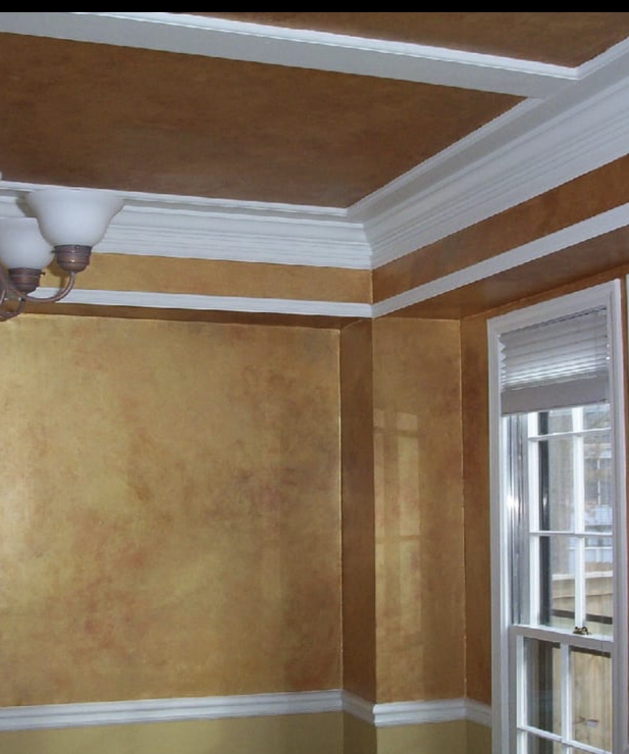 Golden faux finish on dining room walls and tray ceiling with white crown molding